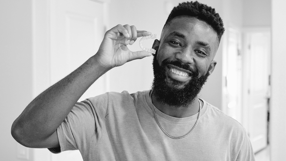 man holding clear aligners
